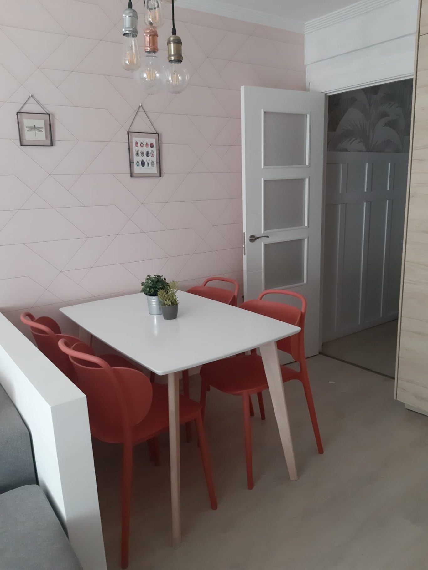 ZONA COMEDOR Comedor moderno con mesa blanca y sillas rojas en un ambiente luminoso y acogedor.