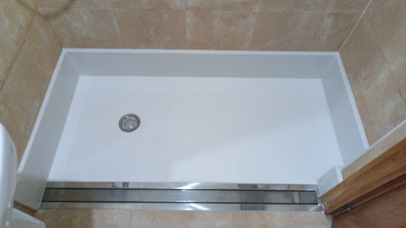 Plato a ras de suelo con desagüe en el centro. canaleta de ducha